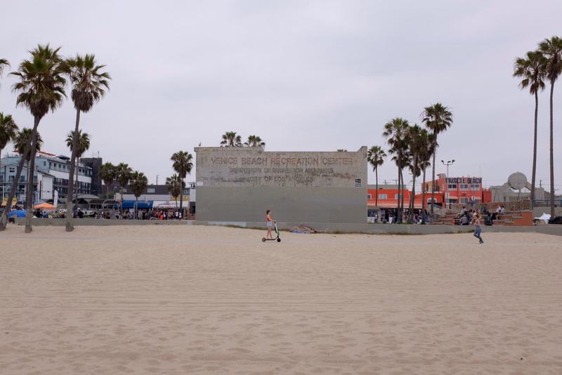 A wide view of Venice Beach with a sign reading "VENICE BEACH RECREATION CENTER" in the background.